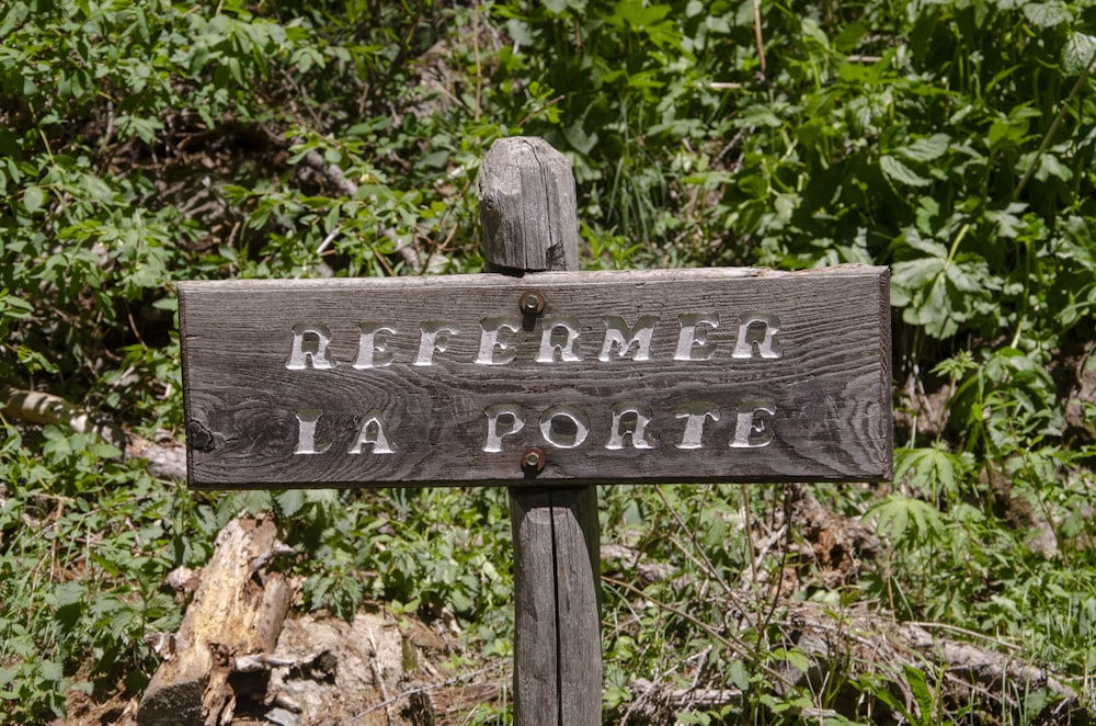 brown wooden signage near green grass field