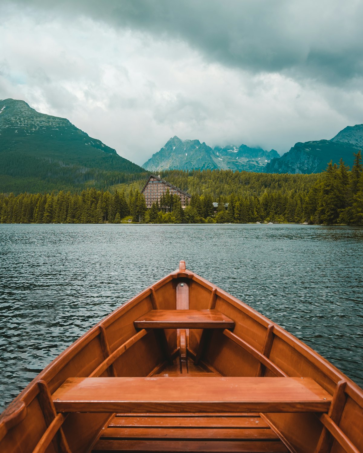 The bow of a wooden boat on a mountain lake
