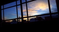 A sunset view through the music academy’s large windows, with silhouettes of students practicing.