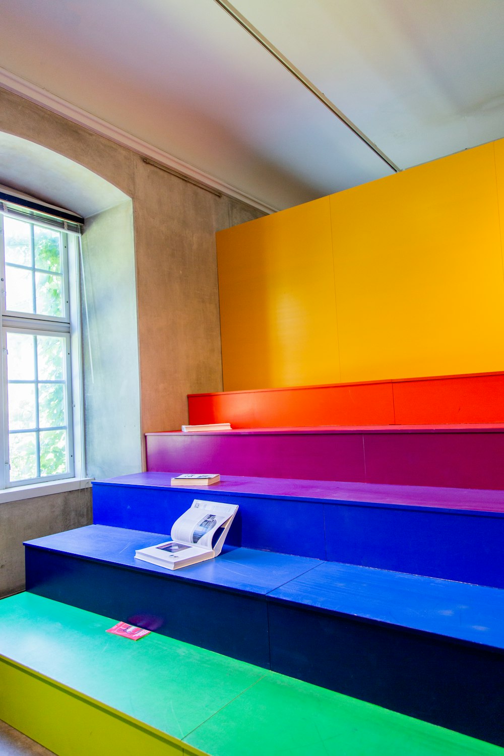 multicolored wooden bleachers inside room beside window