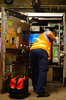 man standing and fixing machine