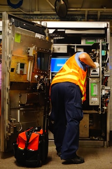 man standing and fixing machine