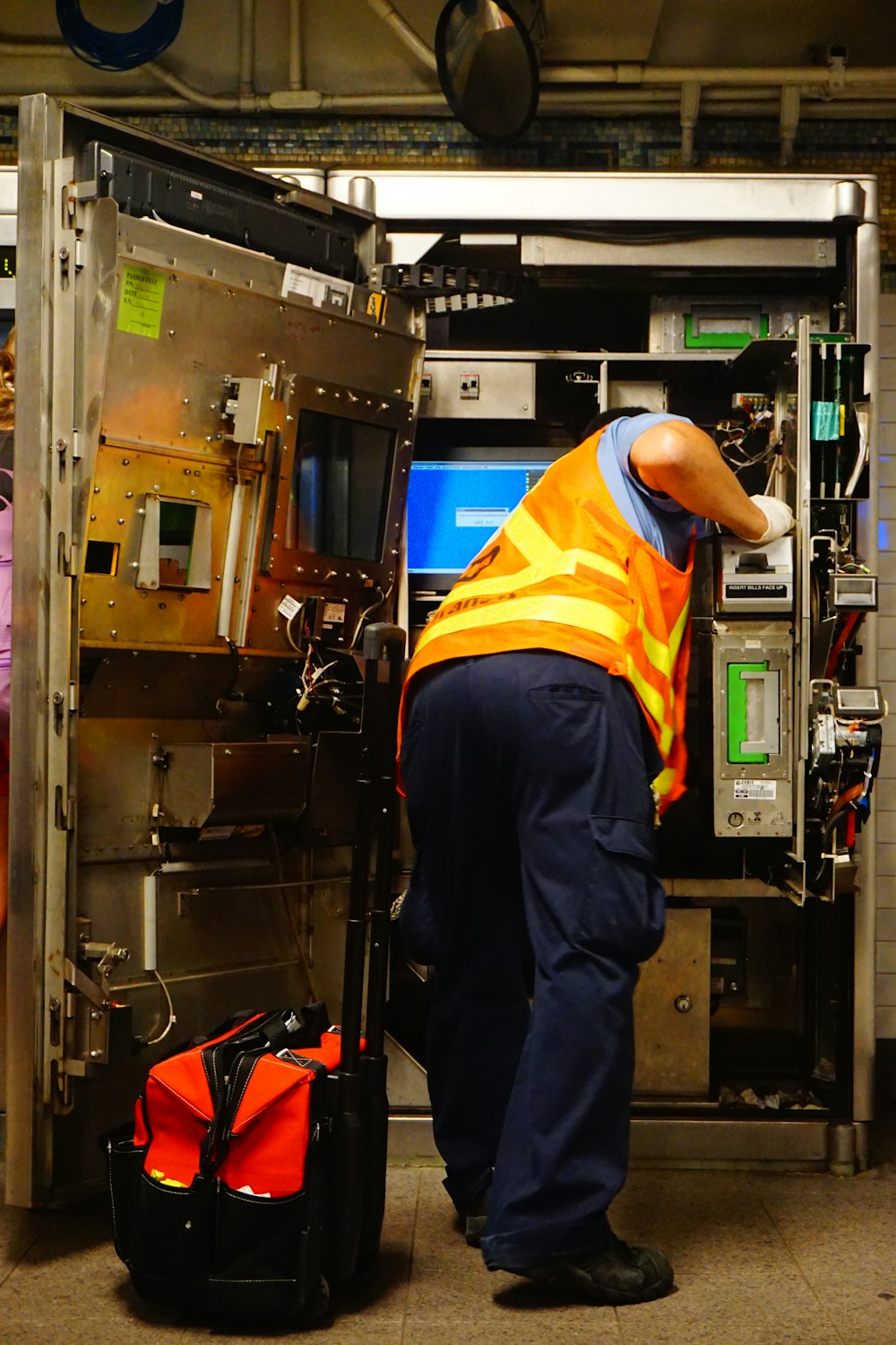 man standing and fixing machine