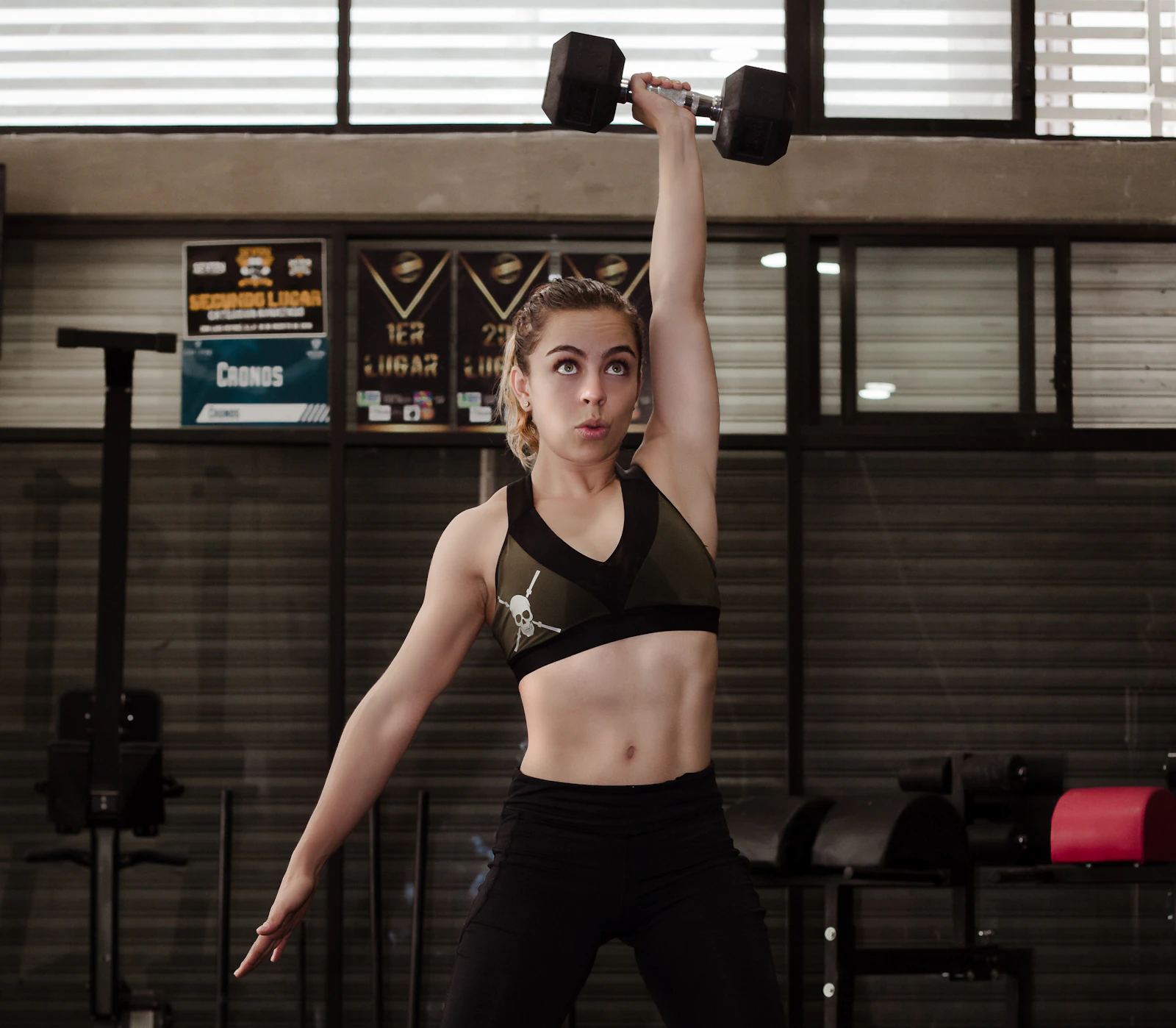 Woman training with dumbbells inside a gym