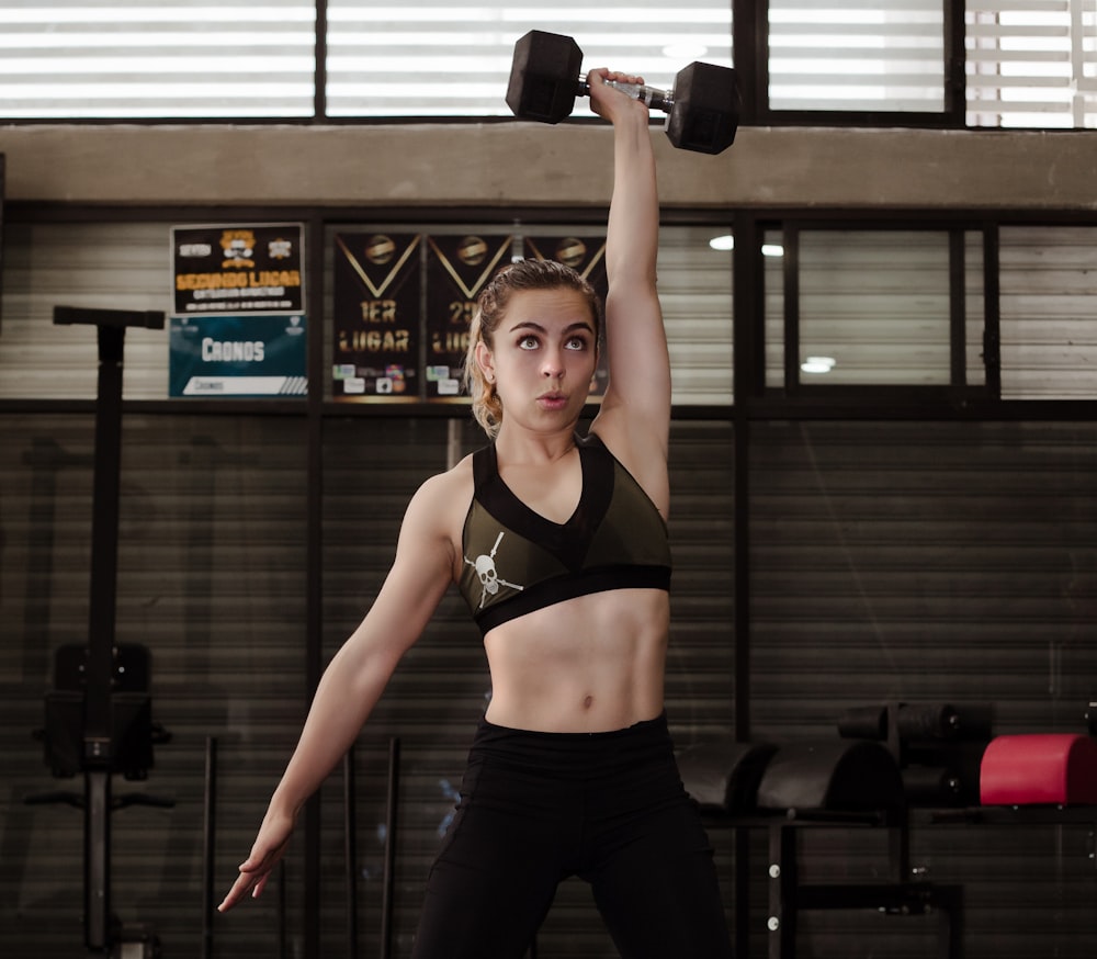 woman exercising with dumbbell inside gym