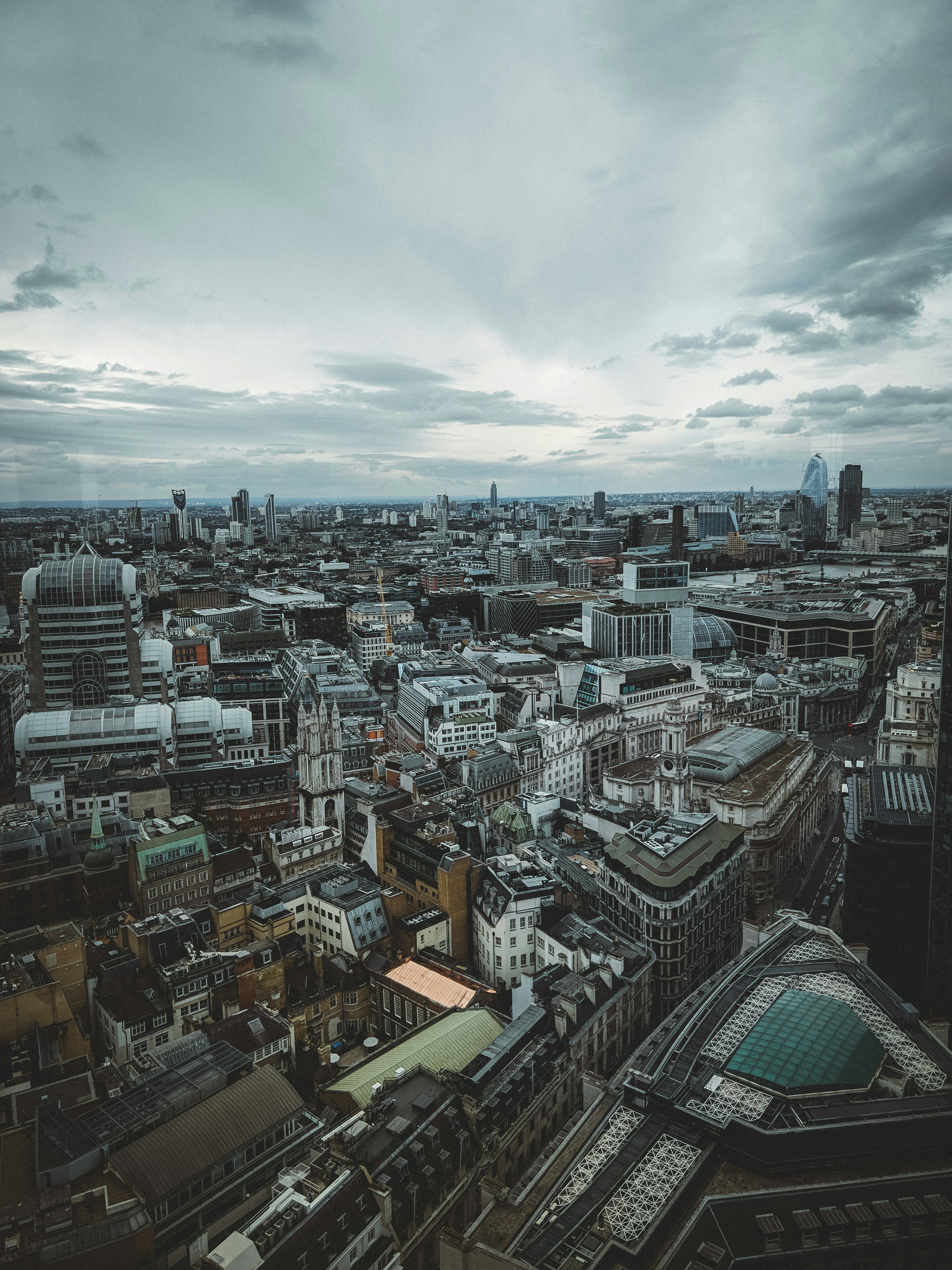 city with high-rise buildings under white and gray skies