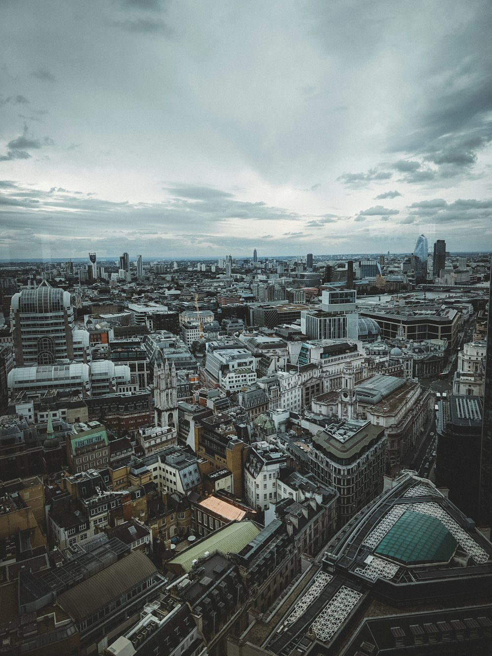 city with high-rise buildings under white and gray skies