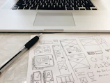 black pen on table beside grey laptop computer