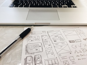 black pen on table beside grey laptop computer