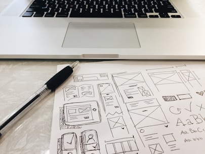 black pen on table beside grey laptop computer