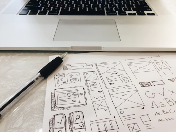 black pen on table beside grey laptop computer