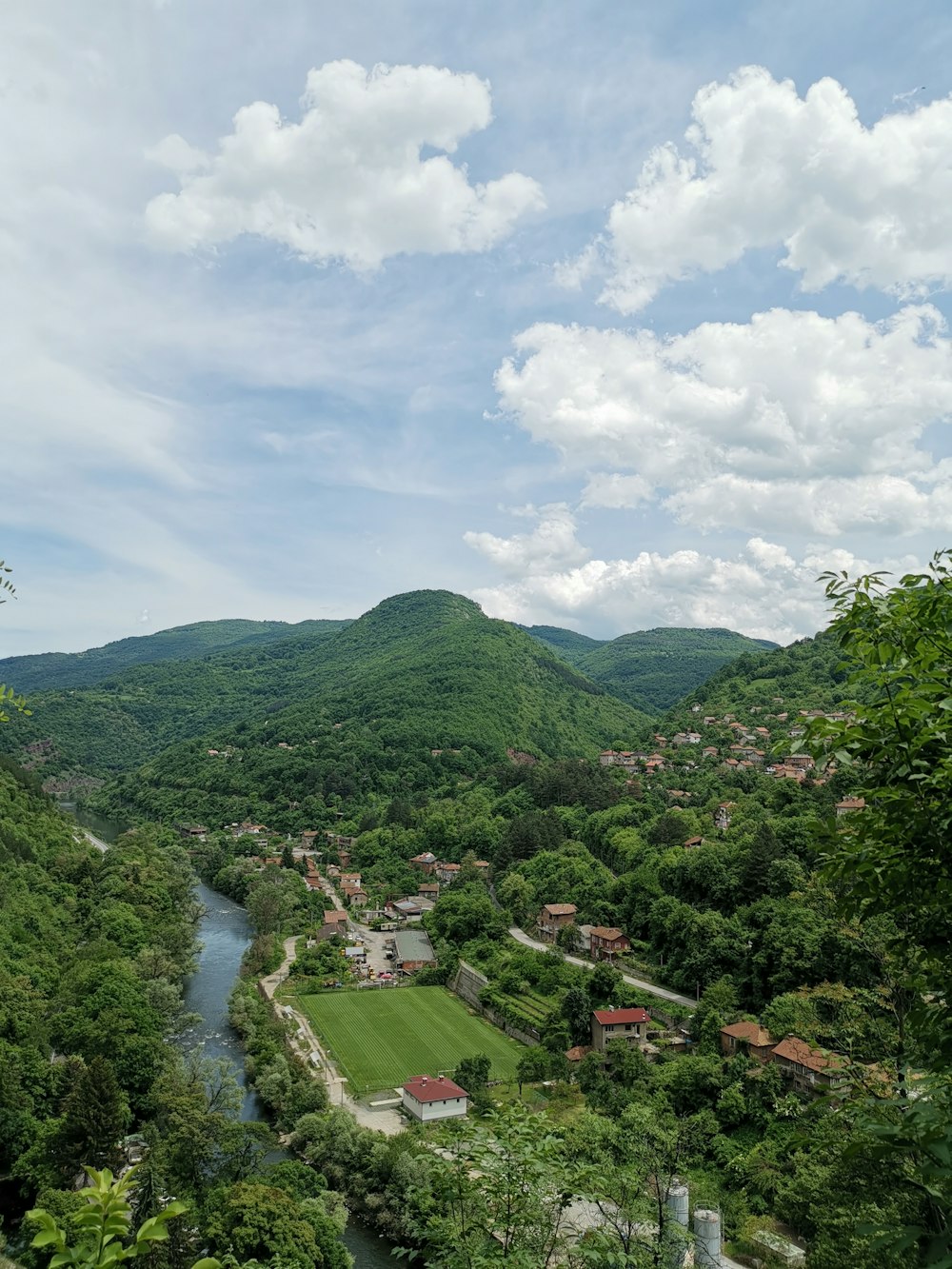 green trees and mountain under white clouds