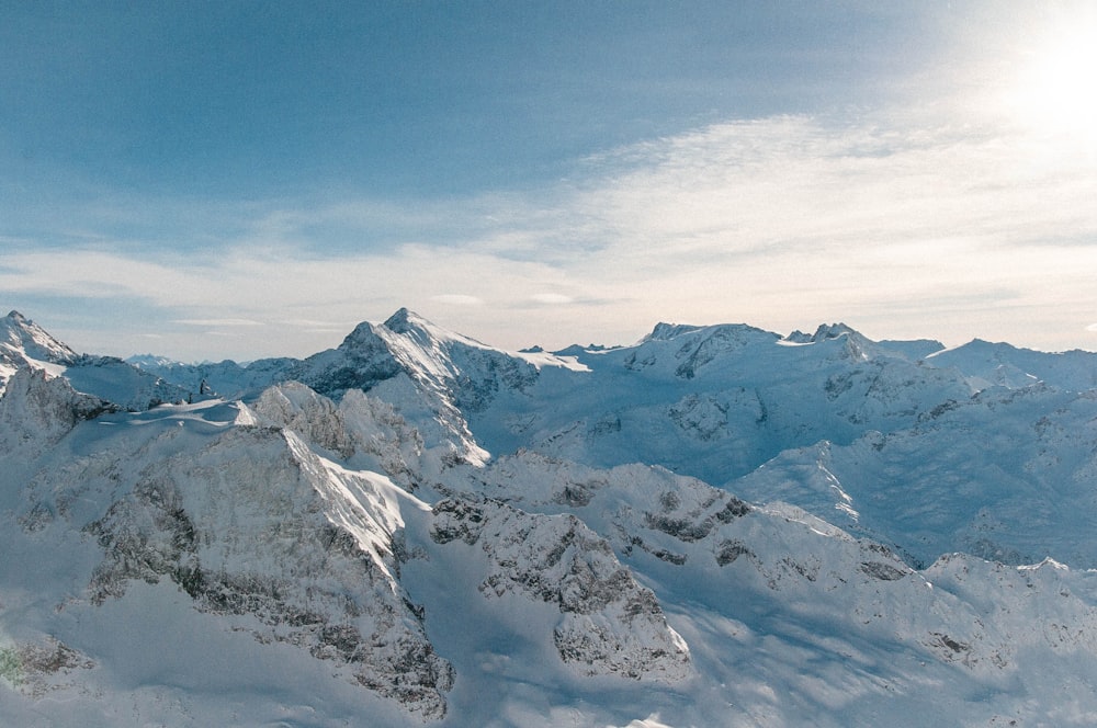 mountain covered with snow under blue and white skies