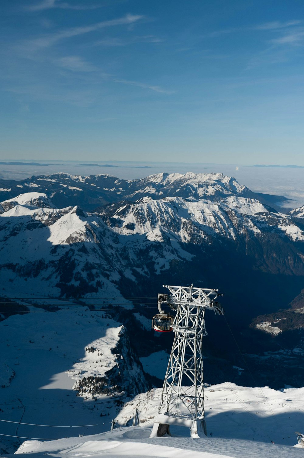 cable car passing above snow mountain