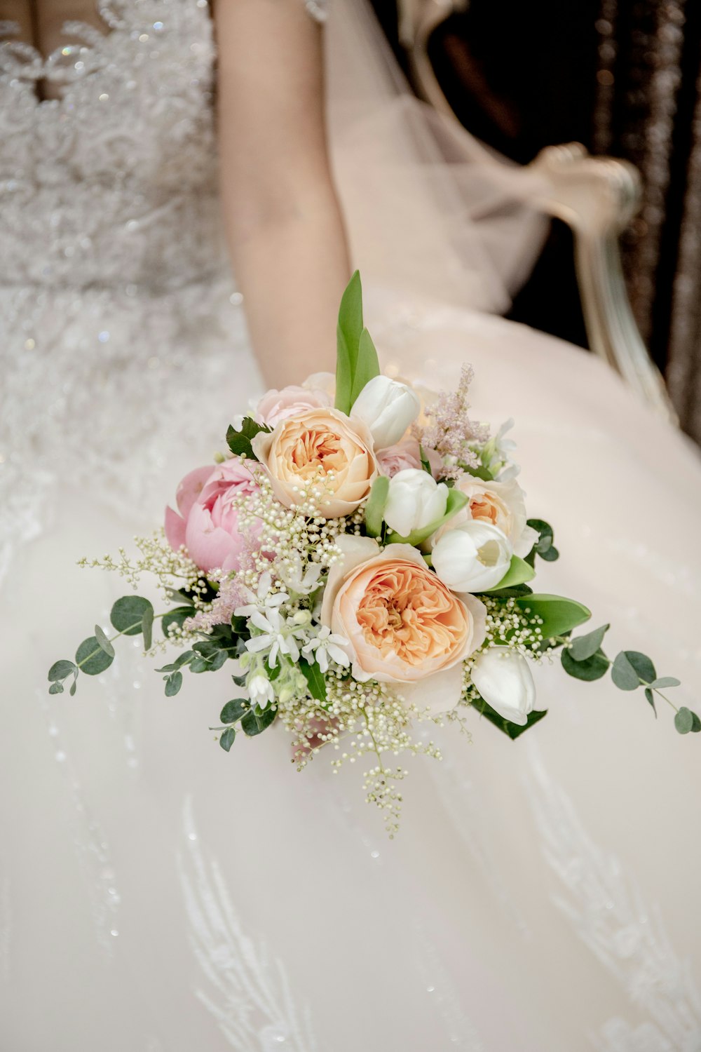 fotografía de enfoque selectivo de mujer sosteniendo ramo de flores