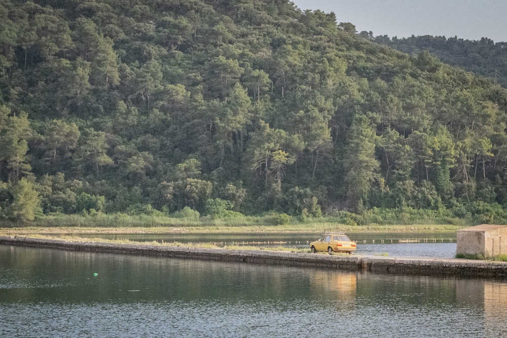 yellow vehicle near body of water