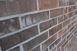 A close-up of a UK residential brick wall showing a subtle horizontal crack under soft daylight.