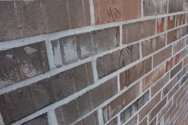 A close-up of a UK residential brick wall showing a subtle horizontal crack under soft daylight.