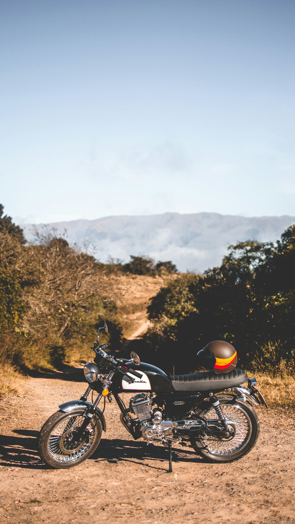 black and orange helmet on black and white standard motorcycle