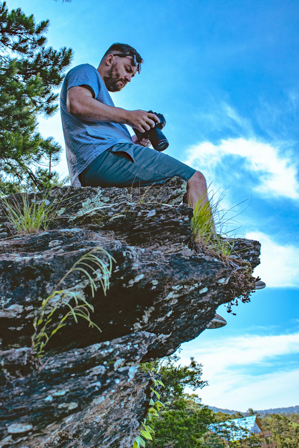 man sitting on creek holding camera