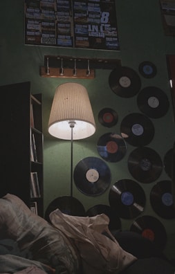 A cozy corner featuring a vintage floor lamp with a faded rose fabric shade.