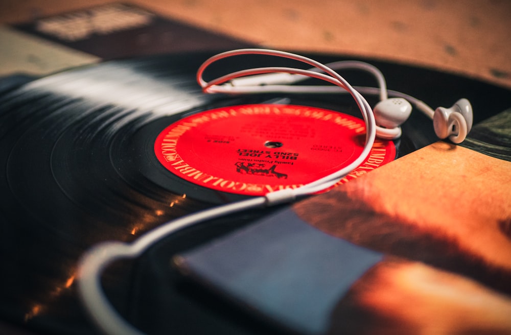 closeup photo of earbuds on LP records