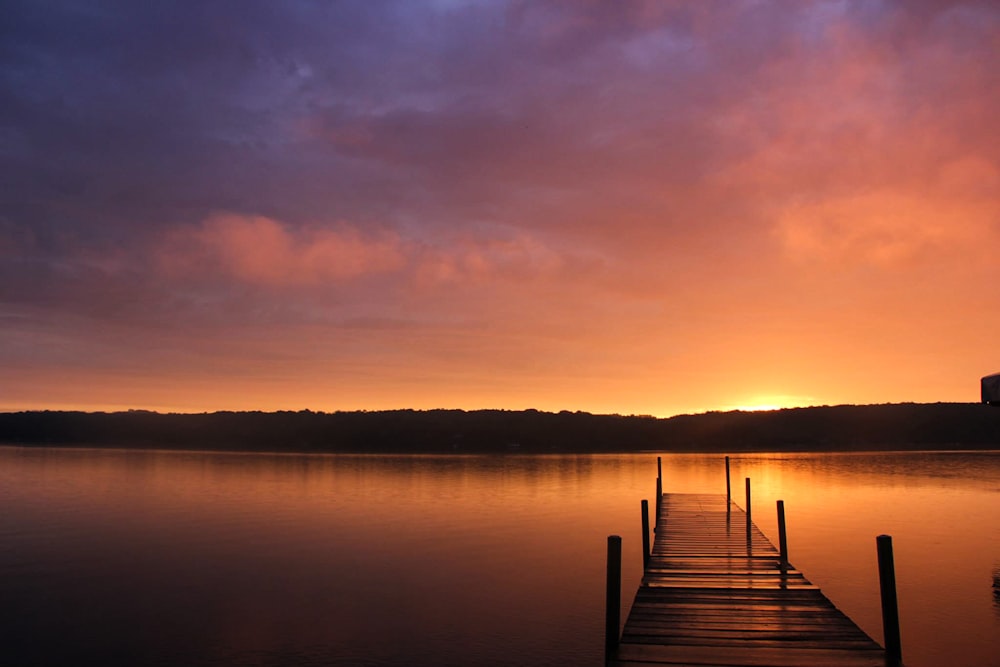 beach dock showing calm sea under sunrise