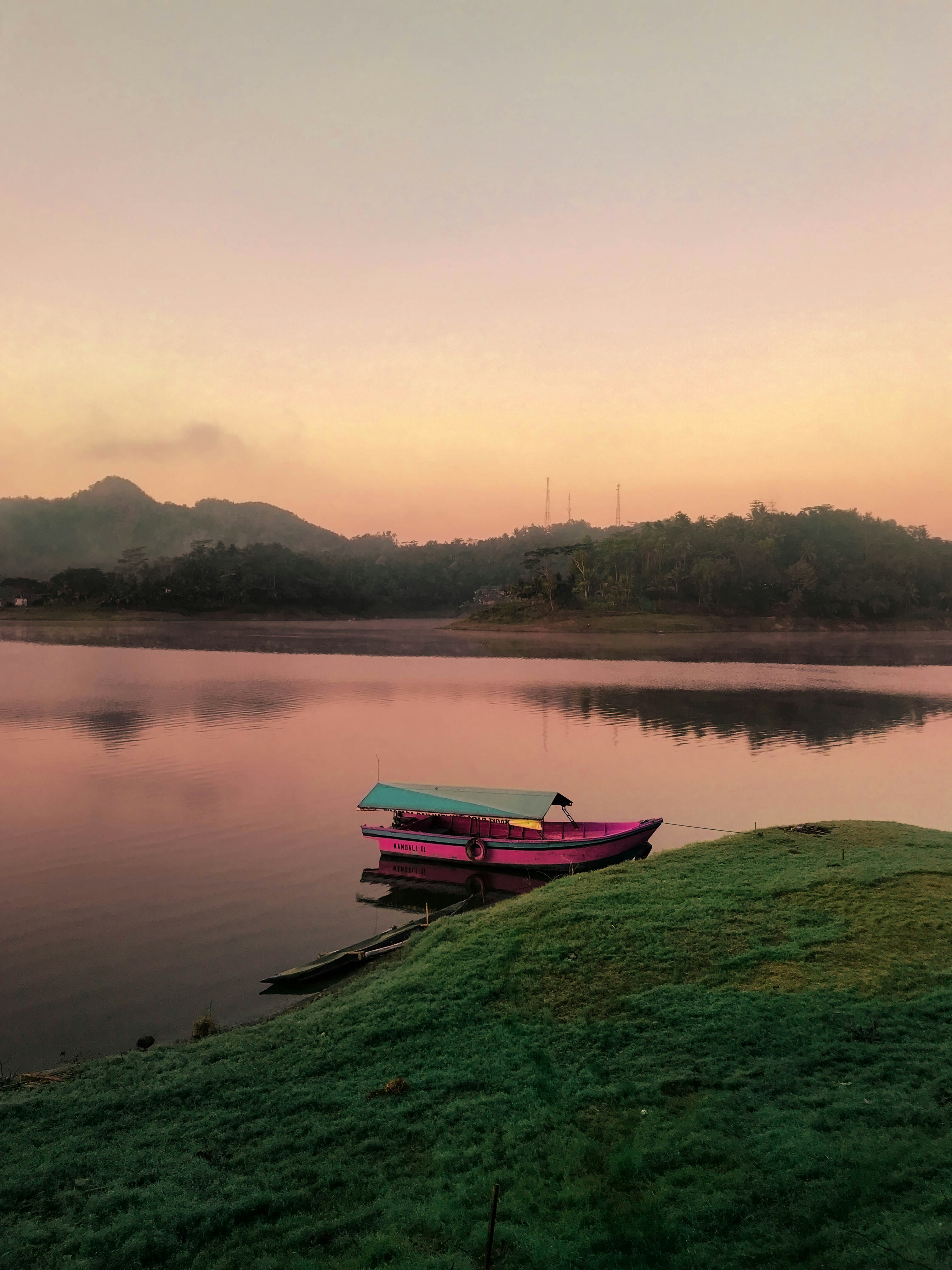 Barca rosa sullo specchio d'acqua accanto all'isola