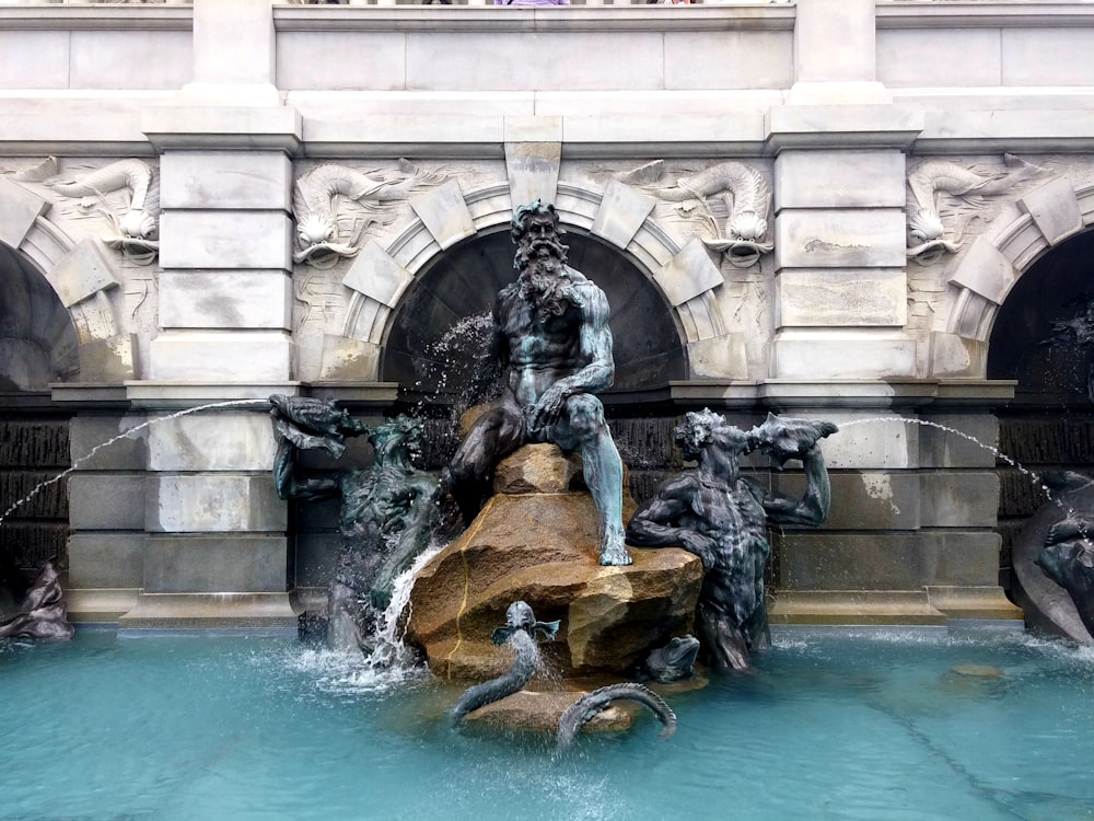 Estatua gris y marrón en el estanque del jardín