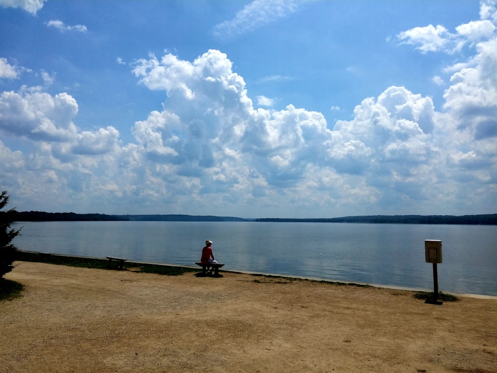 man sitting in front of body of water