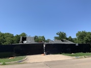 Homeowner speaking on phone with a storm cleanup contractor outside their house.