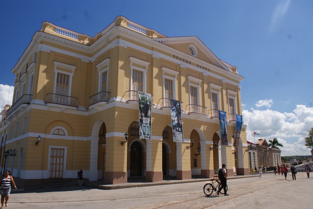 people walking in front of brown and white building