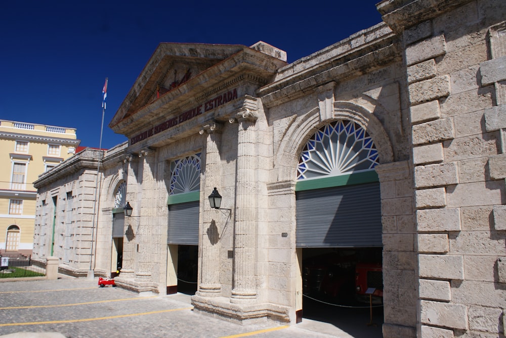 grey building with three roll-up doors opened