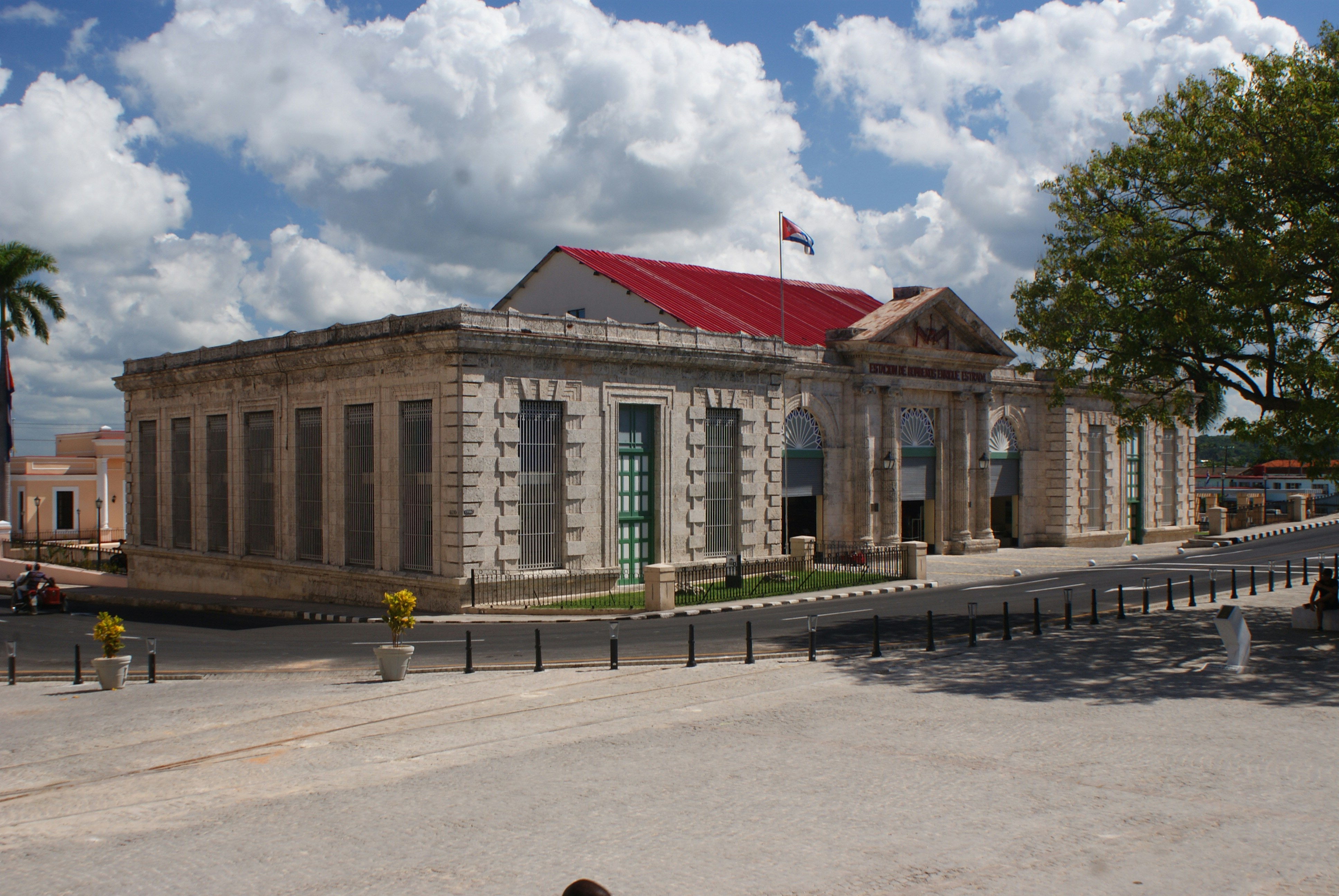 white concrete buildings near trees under blue and white skies