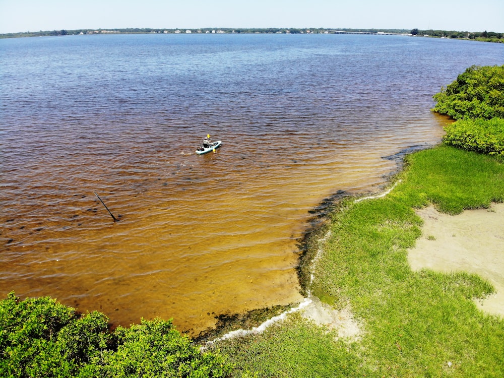 person sitting on kayak near green field