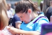 An athlete signing a jersey with focused attention under bright lights.