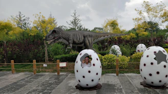 A guest walking alongside towering, lifelike dinosaurs in a lush prehistoric jungle setting.