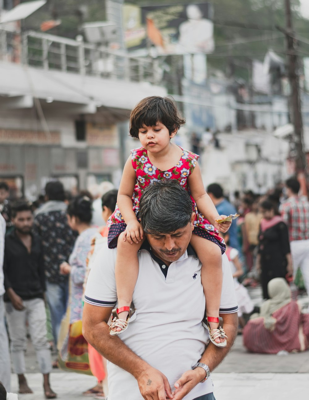 girl sitting on man's neck