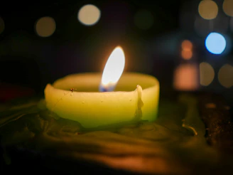 Close-up of a mosquito repellent candle burning gently on a wooden table.