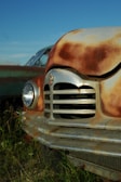 A close-up of a rusty car frame against a clear sky.