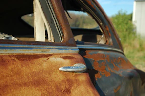 Rust-free used car door with intact window glass against white backdrop
