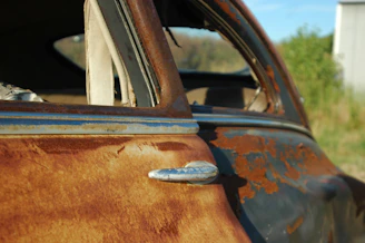 Rust-free used car door with intact window glass against white backdrop