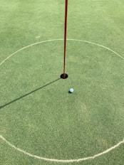 Close-up of a golf ball near the hole on the 4th green.