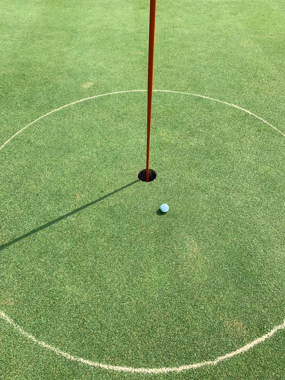 blue golf ball near golf hole