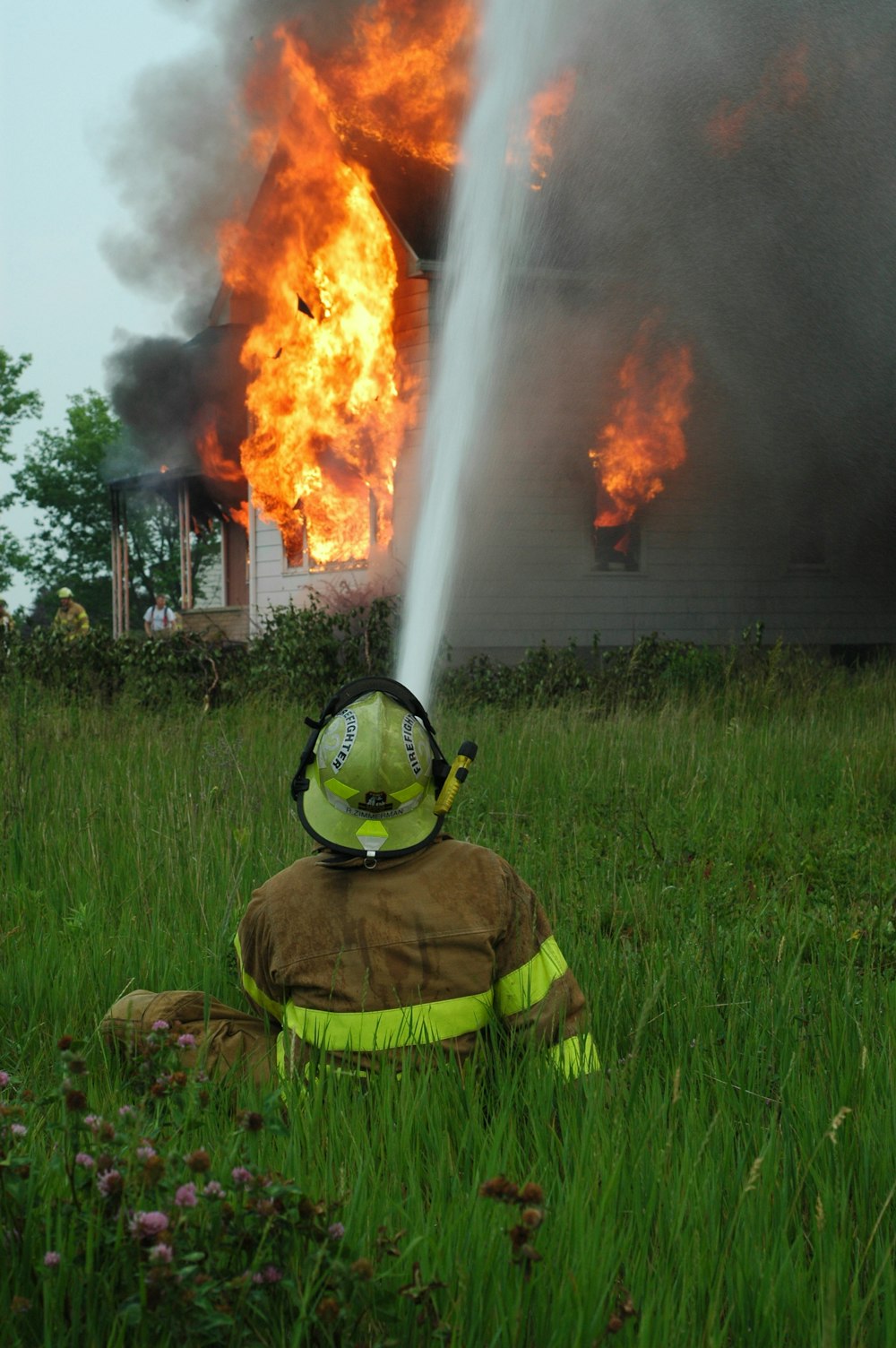 homme près de la maison en flammes