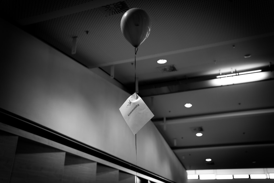 grayscale photography of floating balloon touching the ceiling