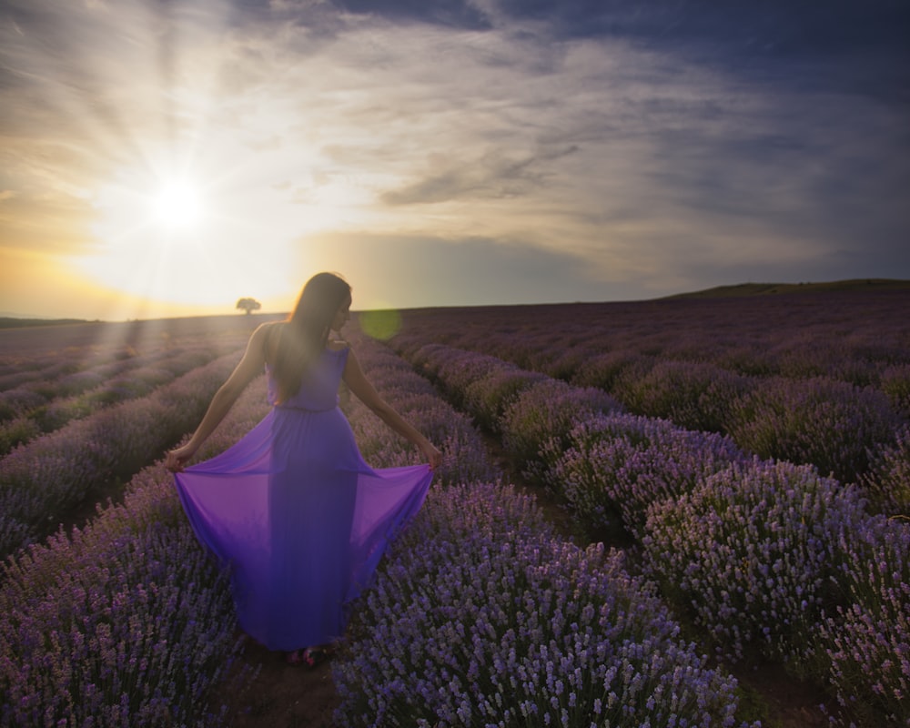 women standing in purple flower plant lot during daytime