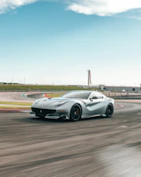 A cinematic shot of a sleek sports car speeding on a racetrack at dusk.
