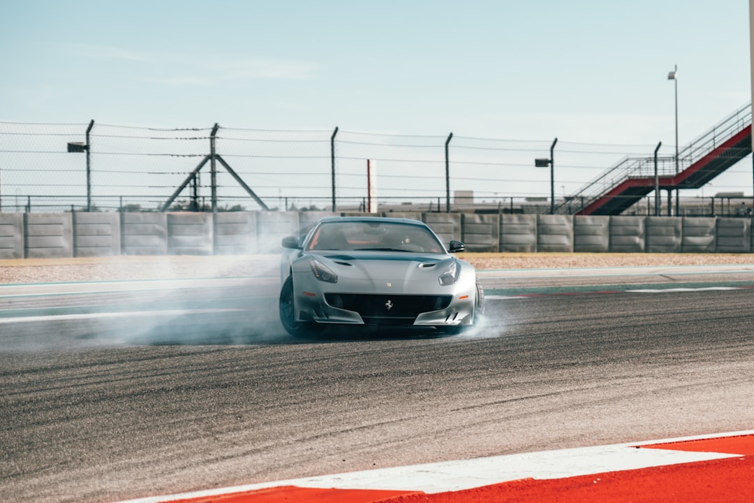 gray sports car across concrete fence with wires