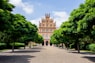 a large building surrounded by trees on a sunny day